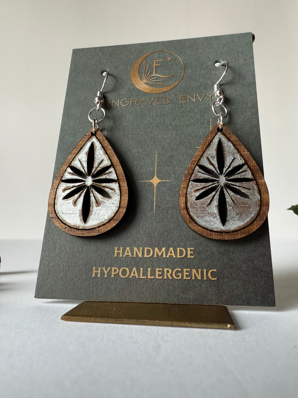 Snowflake drop earring on walnut wood