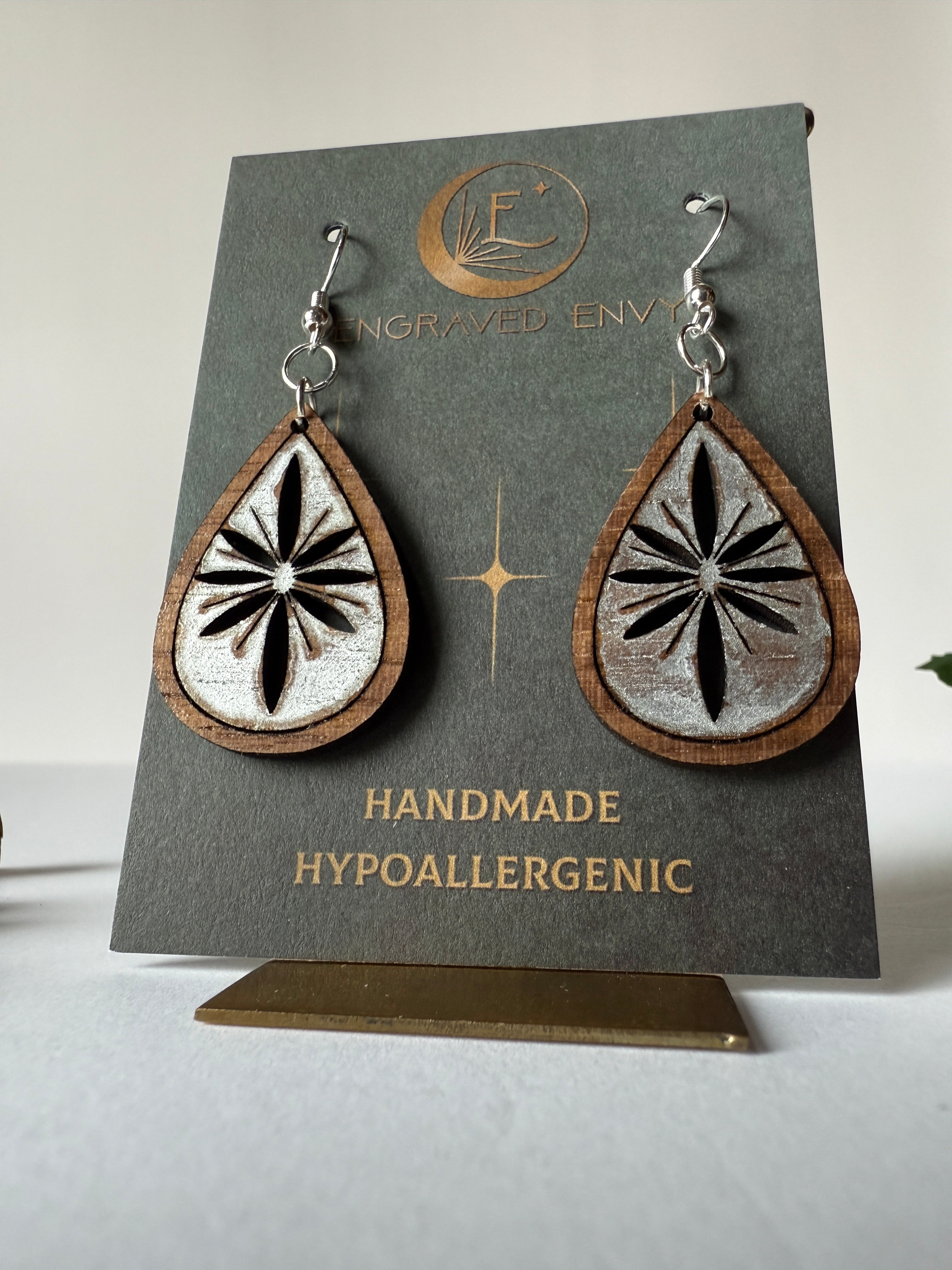 Snowflake drop earring on walnut wood