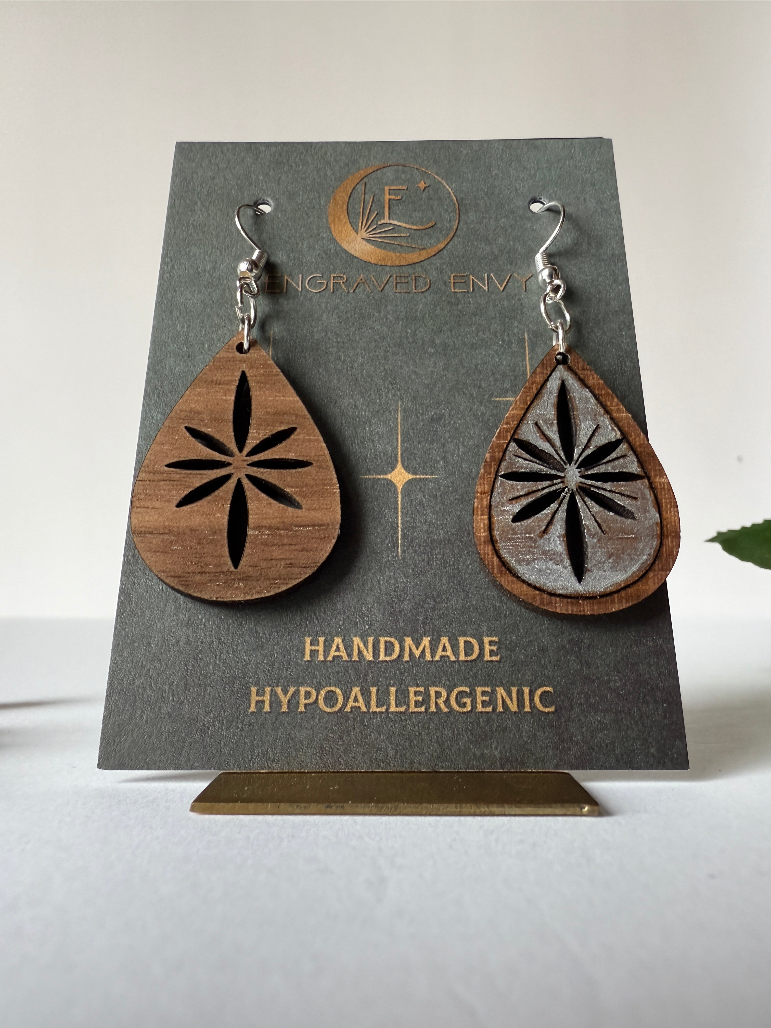 Snowflake drop earring on walnut wood